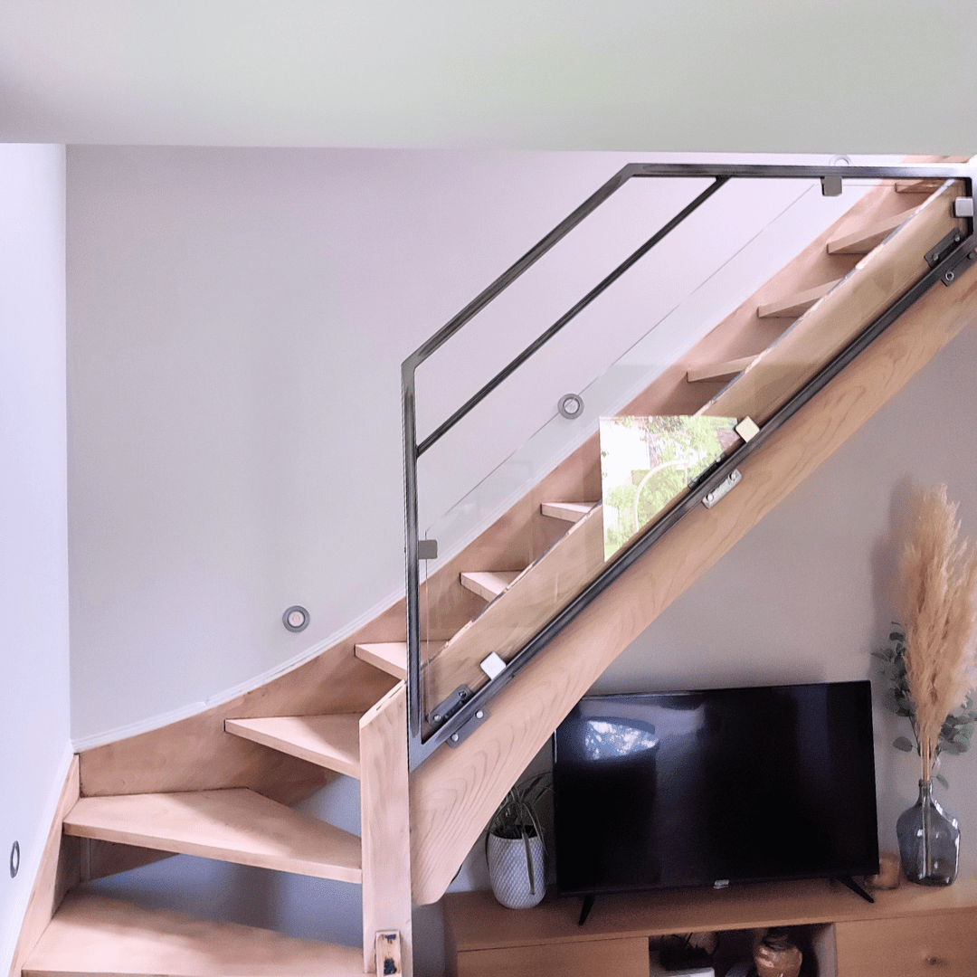 Garde-corps sur-mesure pour escalier intérieur en verre et acier brut verni fabriqué artisanalement dans le Haut-Doubs.