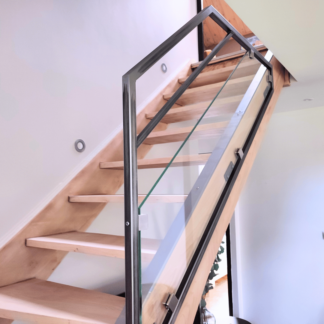 Garde-corps sur-mesure pour escalier intérieur en verre et acier brut verni fabriqué artisanalement dans le Haut-Doubs.