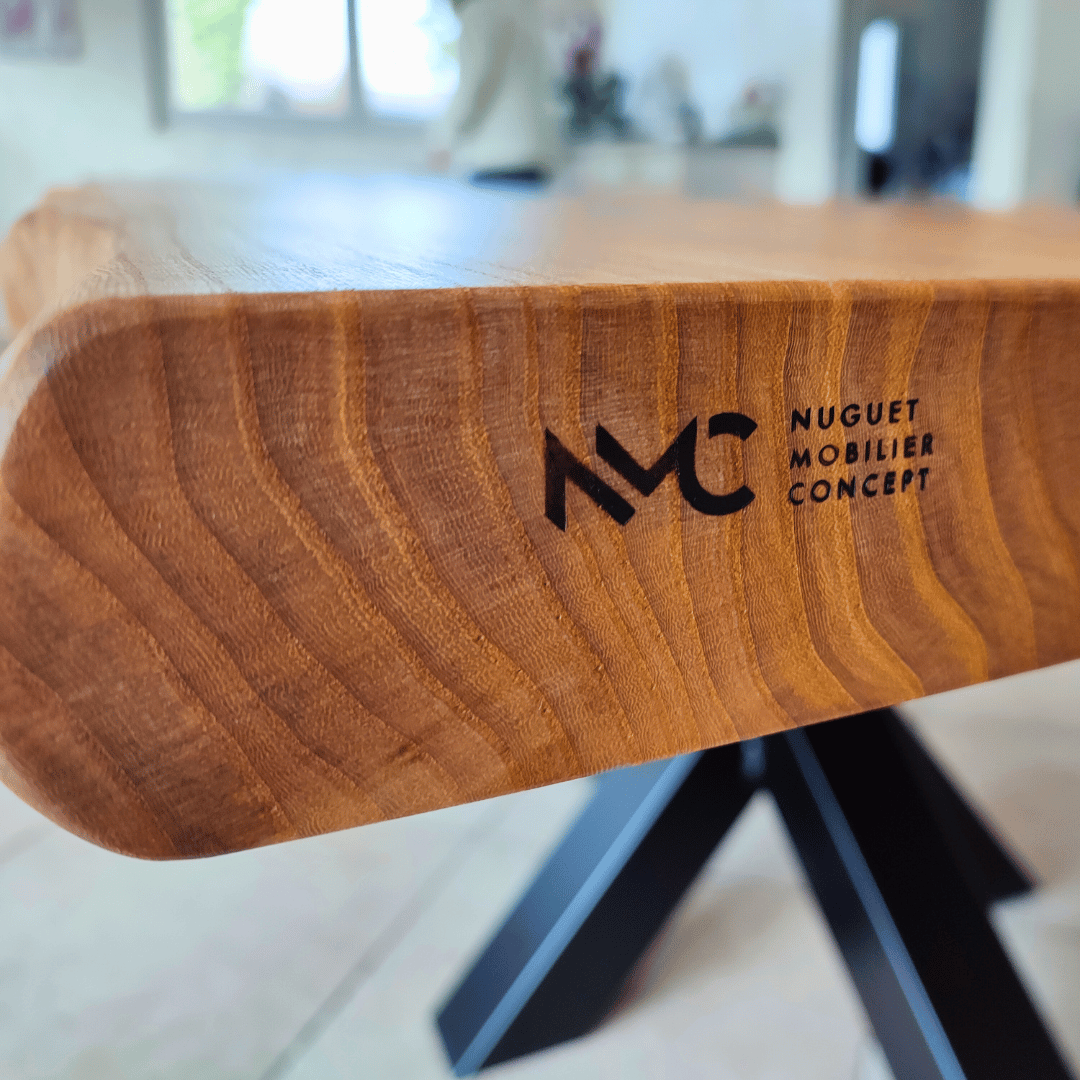 Logo NMC sur bord du plateau de table en orme massif.